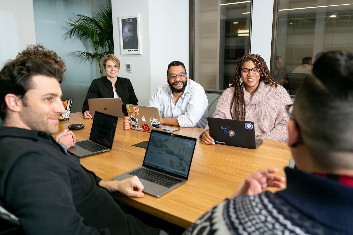 A diverse US engineering team collaborating in a modern office — the kind of senior team Aiinfox builds AI systems with on US engagements (Frisco TX office + Mohali HQ).